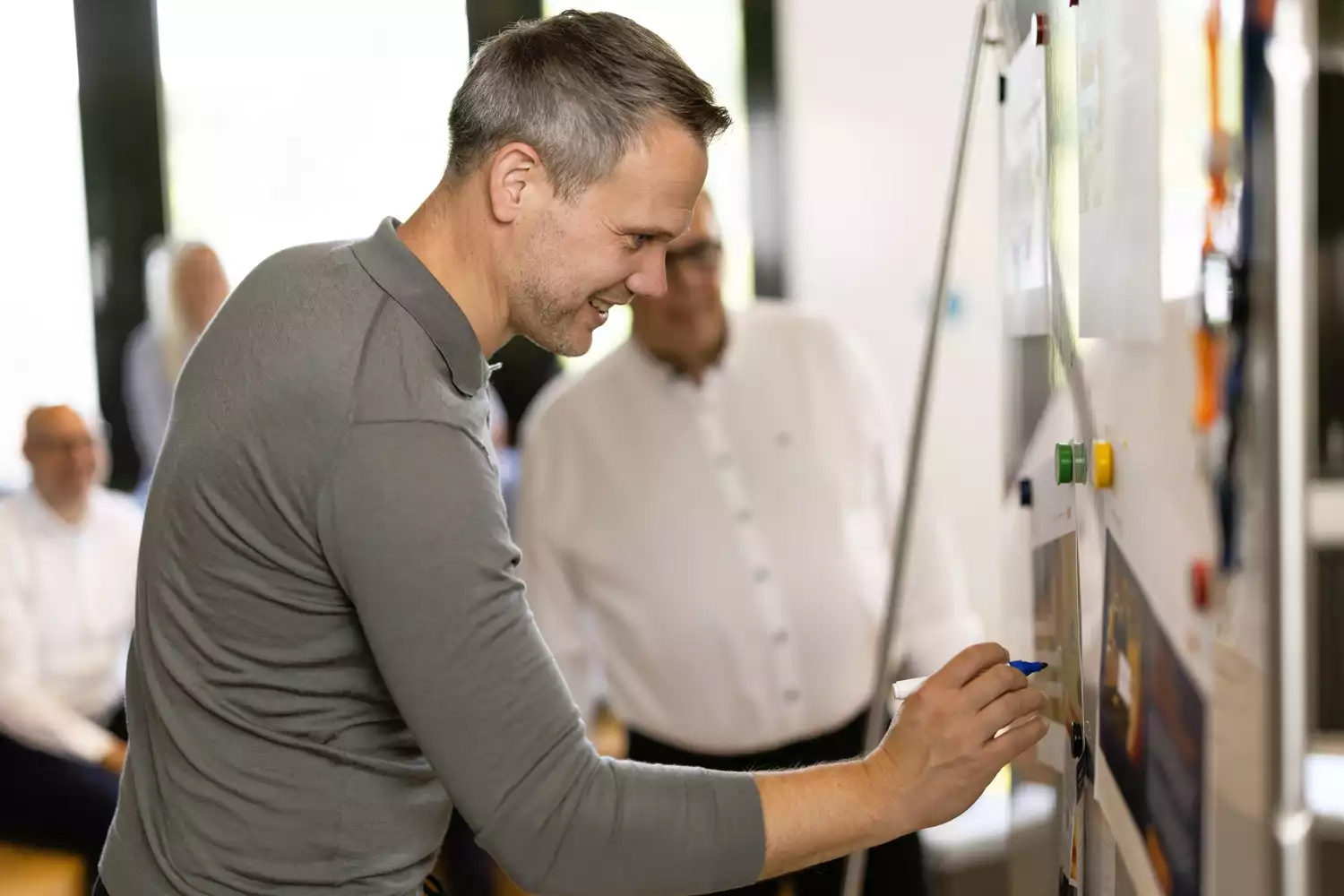 Mann schreibt am Whiteboard im Workshop, Teammeeting und Projektplanung